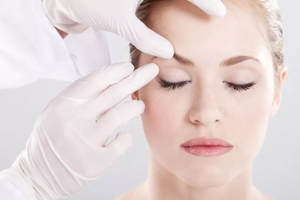 O esteticista examina a pel arredor dos ollos arredor dos ollos